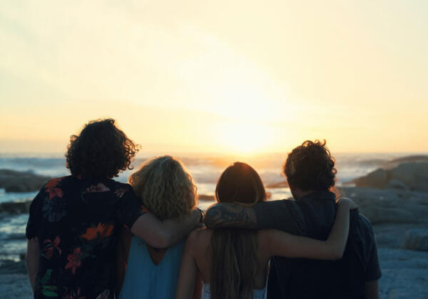 Group of friends on holiday watching sunset